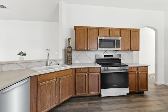 107 Chandler View Trl, Round Rock, TX 78665 - kitchen with appliances with stainless steel finishes, dark wood-style floors, backsplash, and brown cabinets