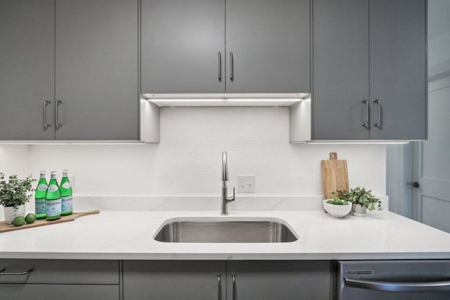 707 Mason St, Leander, TX 78641 - kitchen with gray cabinetry, stainless steel dishwasher, and light stone countertops
