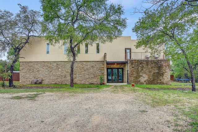 11300 Lake Dr, Austin, TX 78748 - back of property featuring french doors, stone siding, stucco siding, and a balcony