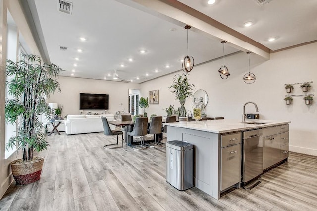 11300 Lake Dr, Austin, TX 78748 - kitchen with stainless steel dishwasher, light wood finished floors, a kitchen island with sink, gray cabinets, and recessed lighting