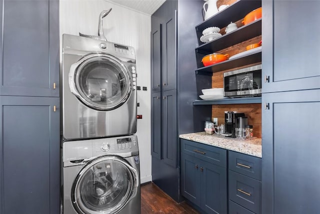 603 E Liberty Ave, Round Rock, TX 78664 - washroom with stacked washing machine and dryer, dark wood-style flooring, and cabinet space