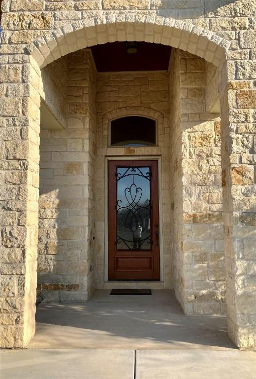 129 S Abrego Xing S, Floresville, TX 78114 - doorway to property with stone siding
