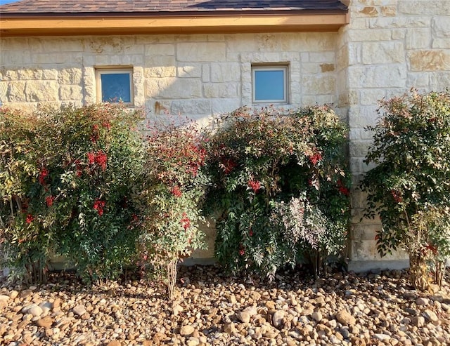 129 S Abrego Xing S, Floresville, TX 78114 - view of side of home with a shingled roof and stone siding