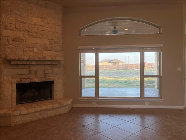 129 S Abrego Xing S, Floresville, TX 78114 - unfurnished living room featuring tile patterned flooring, healthy amount of natural light, ceiling fan, and a fireplace