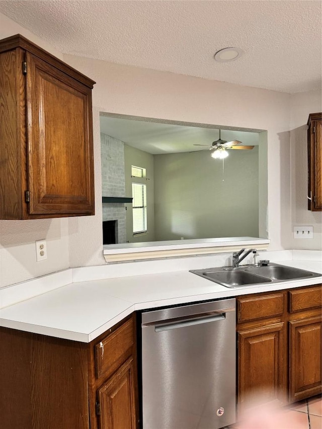 1000 Twin Creek Dr, Pflugerville, TX 78660 - kitchen featuring dishwasher, a ceiling fan, light countertops, a textured ceiling, and a fireplace