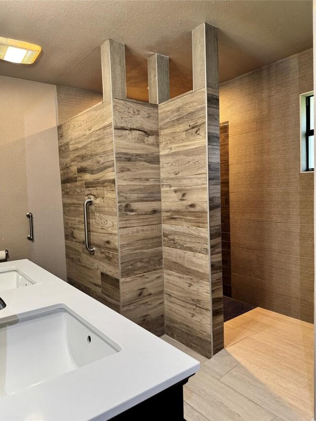 1000 Twin Creek Dr, Pflugerville, TX 78660 - full bathroom with double vanity, a tile shower, and a textured ceiling