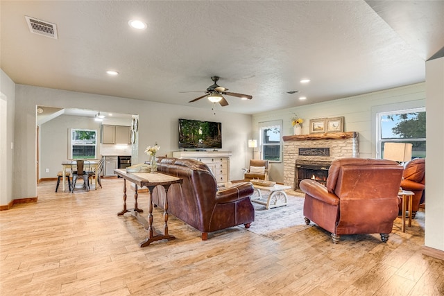 2308 Flite Acres Rd, Wimberley, TX 78676 - living room with a fireplace, light wood-style floors, a ceiling fan, plenty of natural light, and recessed lighting