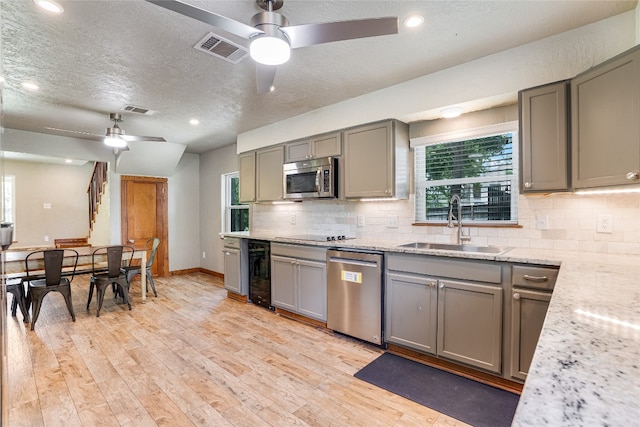 2308 Flite Acres Rd, Wimberley, TX 78676 - kitchen featuring stainless steel appliances, gray cabinetry, wine cooler, a ceiling fan, and a textured ceiling