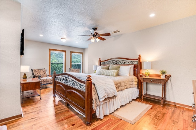 2308 Flite Acres Rd, Wimberley, TX 78676 - bedroom with light wood-style floors, a textured ceiling, and ceiling fan