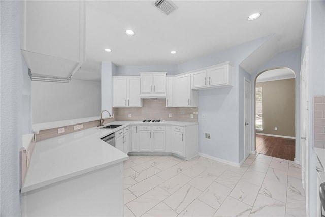 1601 Michael Robert Way, Cedar Park, TX 78613 - kitchen with arched walkways, white cabinetry, recessed lighting, backsplash, and light countertops