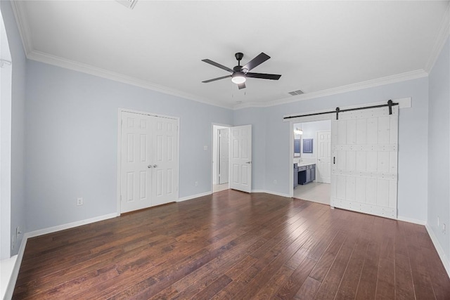 1601 Michael Robert Way, Cedar Park, TX 78613 - unfurnished bedroom with a barn door, hardwood / wood-style flooring, crown molding, a closet, and a ceiling fan