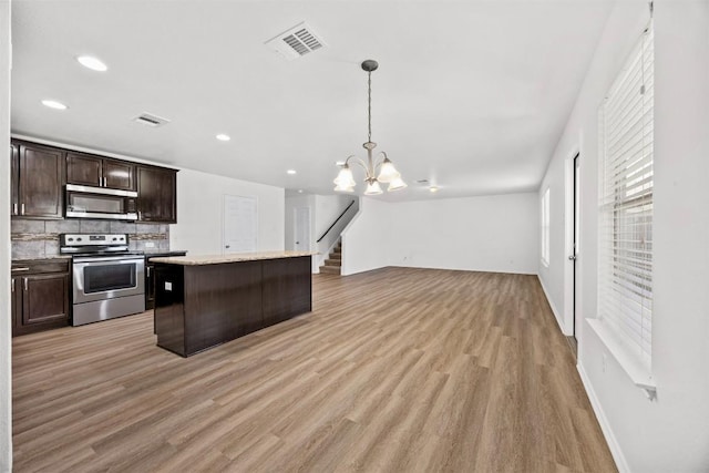 9207 Sandyford Ct, Killeen, TX 76542 - kitchen with appliances with stainless steel finishes, open floor plan, dark brown cabinets, light wood-style flooring, and a kitchen island