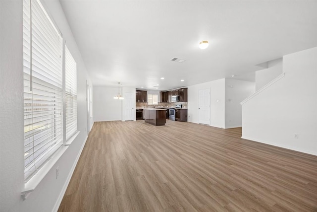 9207 Sandyford Ct, Killeen, TX 76542 - unfurnished living room featuring light wood-style flooring, recessed lighting, and a chandelier