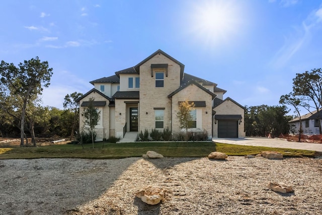 4612 Destination Way, Jonestown, TX 78645 - view of front facade featuring concrete driveway, a garage, stone siding, and a front lawn