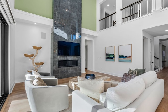 4612 Destination Way, Jonestown, TX 78645 - living room with a high ceiling, a tile fireplace, and wood finished floors