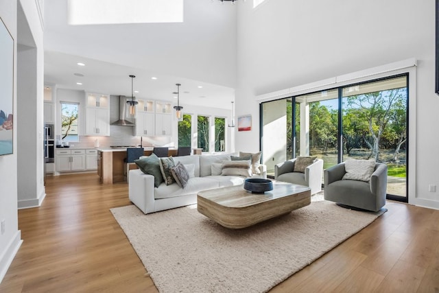 4612 Destination Way, Jonestown, TX 78645 - living room with light wood-type flooring, recessed lighting, a high ceiling, and a skylight