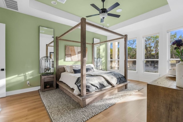 4612 Destination Way, Jonestown, TX 78645 - bedroom with light wood-type flooring, a tray ceiling, and ceiling fan
