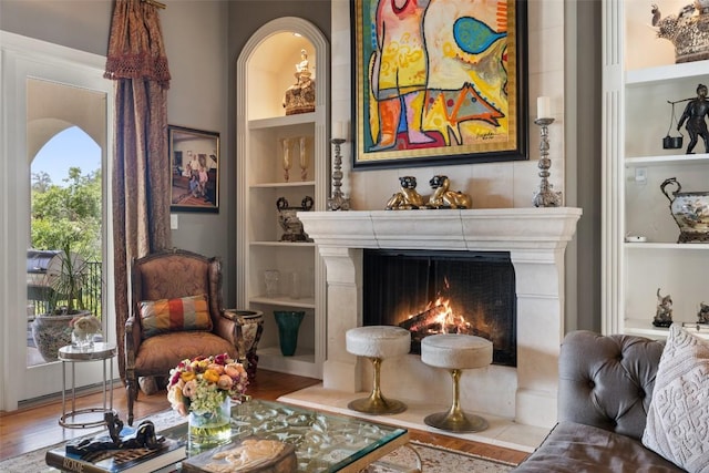 117 Bella Cima Dr, Austin, TX 78734 - living room with built in shelves, a lit fireplace, and wood finished floors