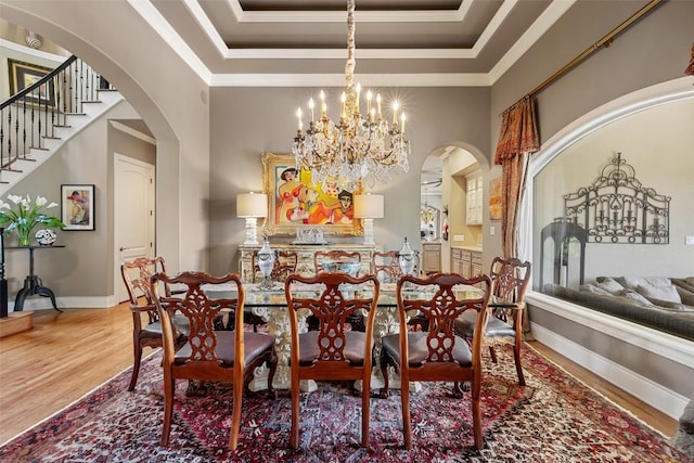 117 Bella Cima Dr, Austin, TX 78734 - dining room featuring arched walkways, wood finished floors, a raised ceiling, and ornamental molding