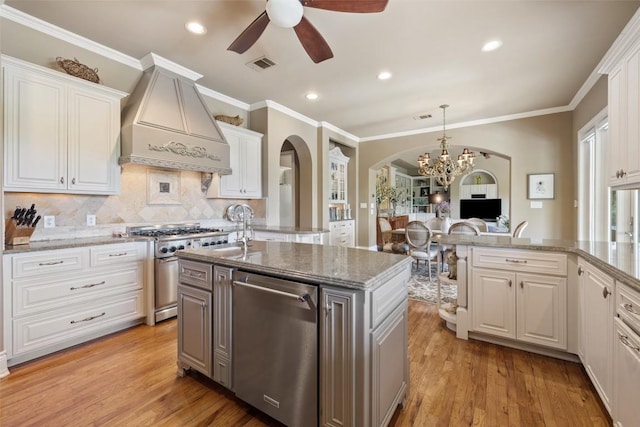 117 Bella Cima Dr, Austin, TX 78734 - kitchen with stainless steel appliances, custom range hood, arched walkways, a ceiling fan, and a chandelier