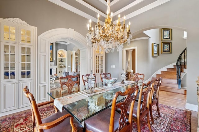117 Bella Cima Dr, Austin, TX 78734 - dining area with arched walkways, crown molding, wood finished floors, stairway, and a chandelier