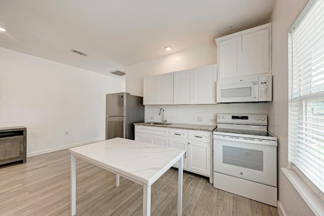 114 Crepe Myrtle Pkwy, Elgin, TX 78621 - kitchen with white appliances, plenty of natural light, light wood-style flooring, white cabinetry, and recessed lighting