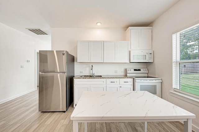 114 Crepe Myrtle Pkwy, Elgin, TX 78621 - kitchen with white appliances, light wood-style flooring, white cabinets, and light stone counters