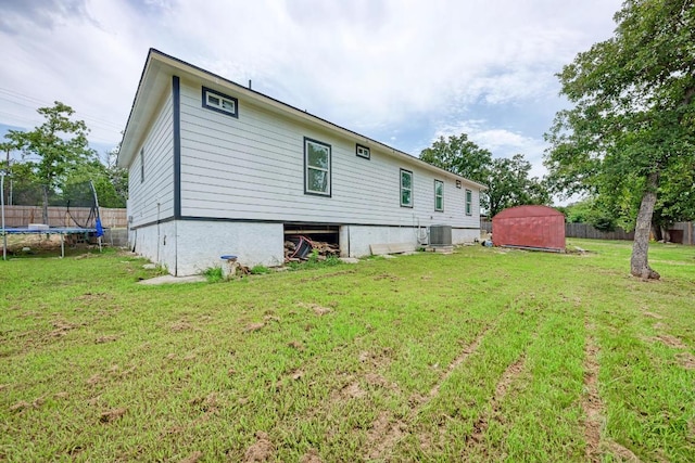 114 Crepe Myrtle Pkwy, Elgin, TX 78621 - rear view of property with a trampoline, a lawn, and a shed