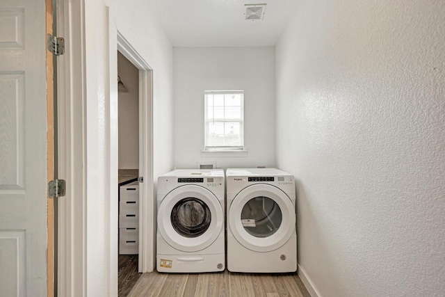 114 Crepe Myrtle Pkwy, Elgin, TX 78621 - laundry room featuring washer and clothes dryer, light wood-style floors, and a textured wall
