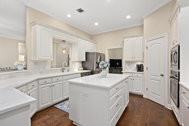 13410 Saddle Back Pass, Austin, TX 78738 - kitchen featuring appliances with stainless steel finishes, a center island, backsplash, ornamental molding, and recessed lighting