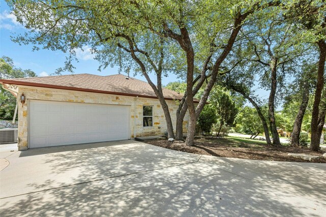 1403 Roaring Frk, Leander, TX 78641 - view of front of property featuring stone siding, driveway, a garage, and roof with shingles