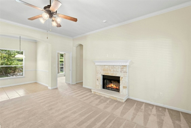 1403 Roaring Frk, Leander, TX 78641 - unfurnished living room with carpet, a ceiling fan, ornamental molding, a stone fireplace, and arched walkways