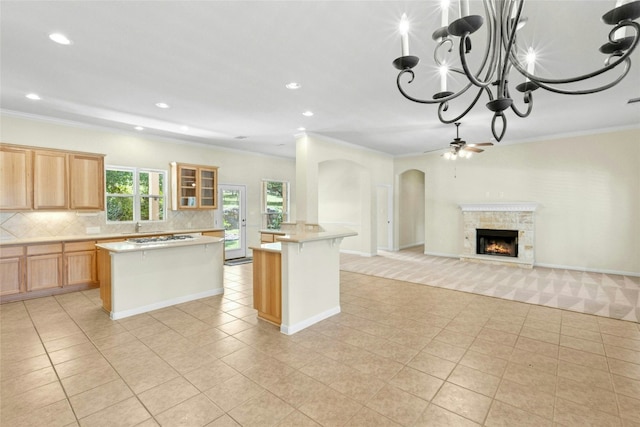 1403 Roaring Frk, Leander, TX 78641 - kitchen featuring a center island, crown molding, light countertops, tasteful backsplash, and arched walkways