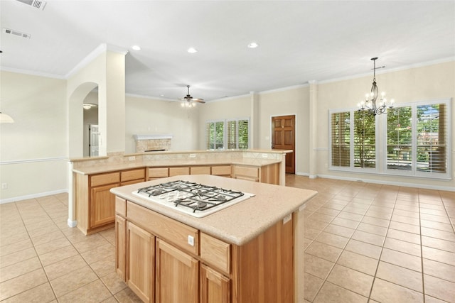 1403 Roaring Frk, Leander, TX 78641 - kitchen featuring light tile patterned floors, white gas cooktop, ceiling fan, open floor plan, and crown molding