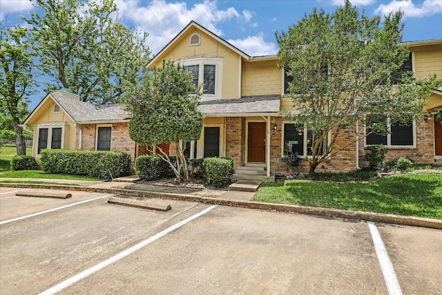 11901 Swearingen Dr Unit 4, Austin, TX 78758 - view of front of property featuring uncovered parking, brick siding, and a front yard