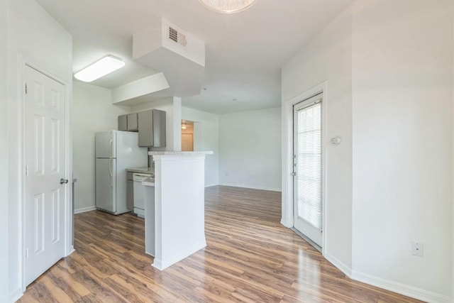2320 Gracy Farms Ln Unit 522, Austin, TX 78758 - kitchen with gray cabinetry, white appliances, wood finished floors, light countertops, and healthy amount of natural light