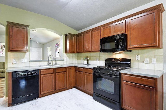 106 Wild Plum, San Marcos, TX 78666 - kitchen featuring black appliances, lofted ceiling, light countertops, arched walkways, and decorative backsplash