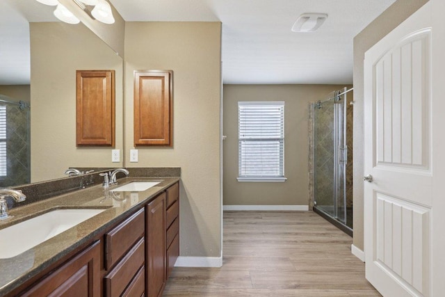 1124 Calla Lily Blvd, Leander, TX 78641 - full bath with double vanity, a shower stall, and wood finished floors