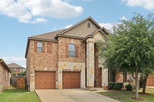 1124 Calla Lily Blvd, Leander, TX 78641 - view of front of house with concrete driveway, a garage, stone siding, and brick siding