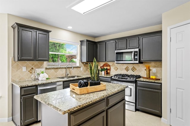 3528 Ruby Red Dr, Austin, TX 78728 - kitchen featuring appliances with stainless steel finishes, light stone countertops, backsplash, a kitchen island, and recessed lighting