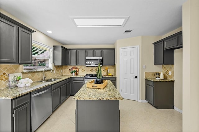 3528 Ruby Red Dr, Austin, TX 78728 - kitchen with appliances with stainless steel finishes, a center island, light stone counters, tasteful backsplash, and recessed lighting