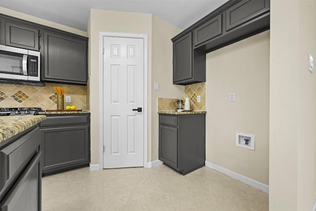 3528 Ruby Red Dr, Austin, TX 78728 - kitchen featuring stainless steel microwave, tasteful backsplash, light stone counters, and light tile patterned flooring