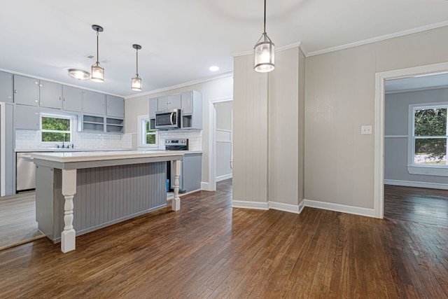1414 E 4th St, Lampasas, TX 76550 - kitchen featuring stainless steel microwave, crown molding, plenty of natural light, dark wood-type flooring, and light countertops