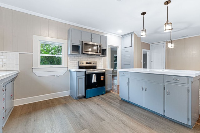 1414 E 4th St, Lampasas, TX 76550 - kitchen featuring appliances with stainless steel finishes, gray cabinets, light wood-style floors, crown molding, and light countertops