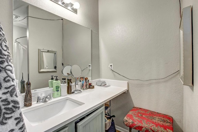 1624 Aquarena Springs Dr Unit B115, San Marcos, TX 78666 - full bath with vanity, a textured wall, and a shower with shower curtain