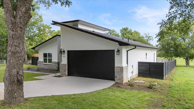 108 Bill St, Elgin, TX 78621 - view of side of property with stone siding, concrete driveway, an attached garage, and stucco siding