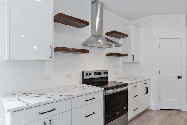 108 Bill St, Elgin, TX 78621 - kitchen with stainless steel electric stove, wall chimney exhaust hood, open shelves, white cabinets, and light wood-style floors