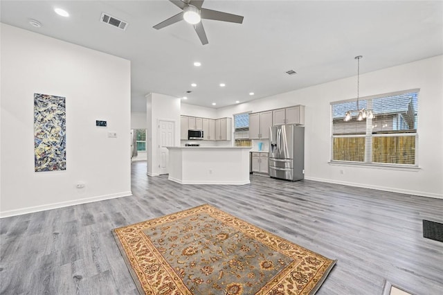 8721 Little Laura Dr, Austin, TX 78757 - unfurnished living room with a ceiling fan, light wood finished floors, a chandelier, and recessed lighting