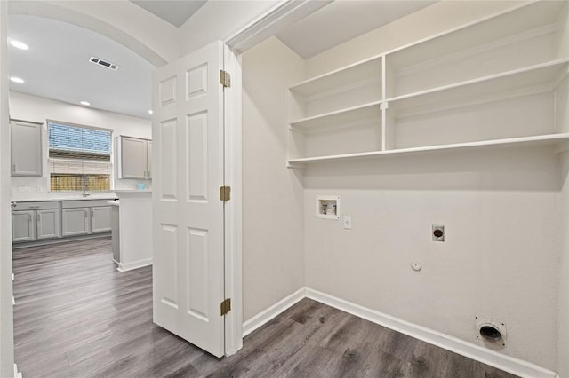8721 Little Laura Dr, Austin, TX 78757 - laundry room with gas dryer hookup, hookup for an electric dryer, hookup for a washing machine, dark wood-style flooring, and arched walkways