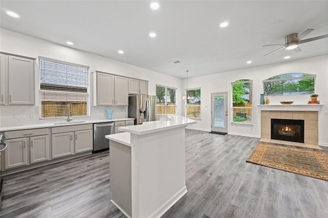 8721 Little Laura Dr, Austin, TX 78757 - kitchen with stainless steel appliances, gray cabinetry, recessed lighting, open floor plan, and a center island